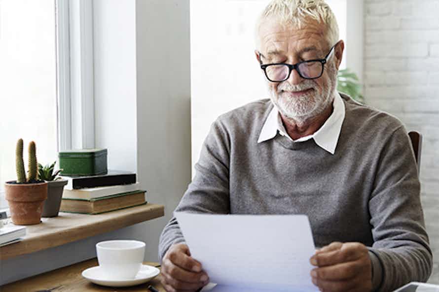 Elderly man reading the Cancer Survivor Resource Guide.